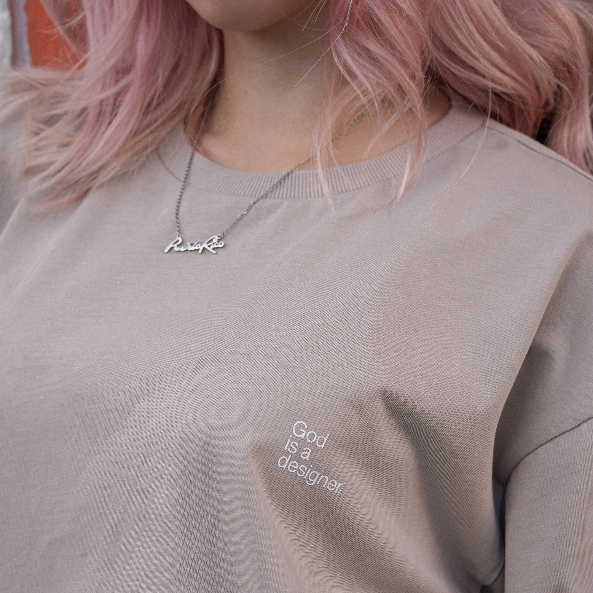 Woman wearing a beige sweatshirt with text, close-up of the garment.