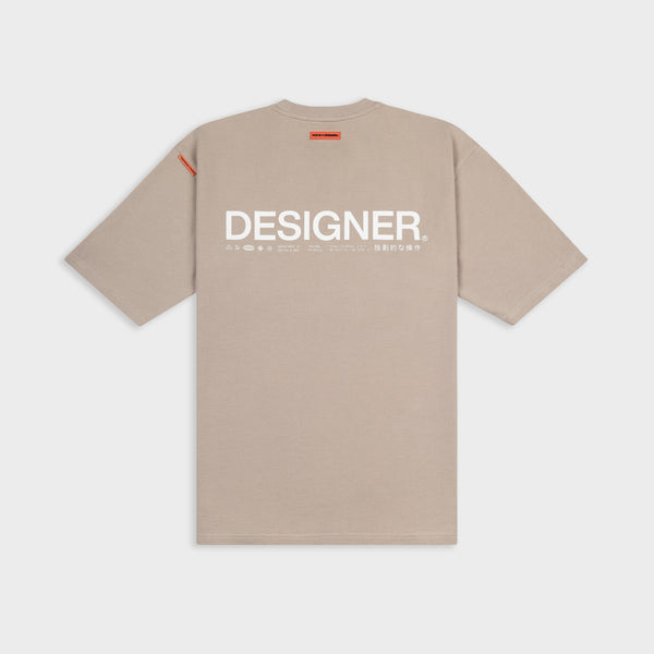 Beige t-shirt with 'DESIGNER' text on a white background